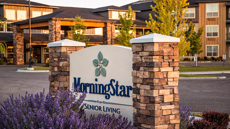 Stone sign with the text 'MorningStar Senior Living' in front of a senior living facility building with trees and landscaping.