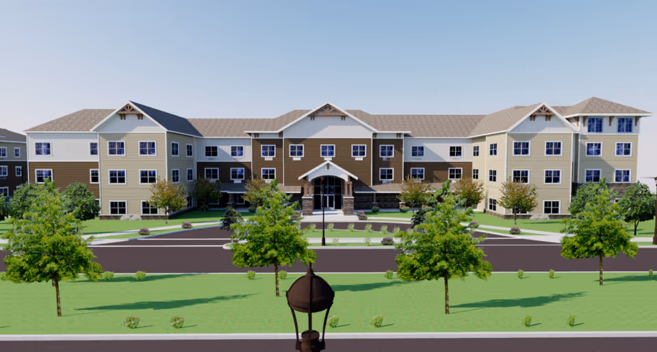 Front exterior of a three-story senior living building with trees, lawn, and a circular driveway.