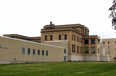 Exterior view of Badger Prairie Health Care Center with brick building and green lawn