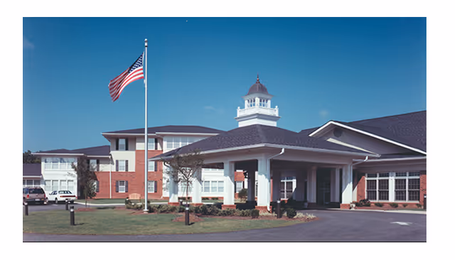 Front exterior of Wesley Woods of Newnan Peachtree City, brick building with American flag.