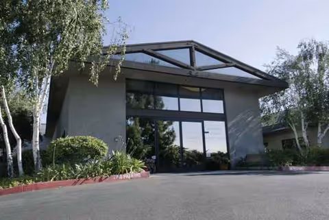 Exterior view of Stanford Court Skilled Nursing & Rehab Center entrance with glass doors.