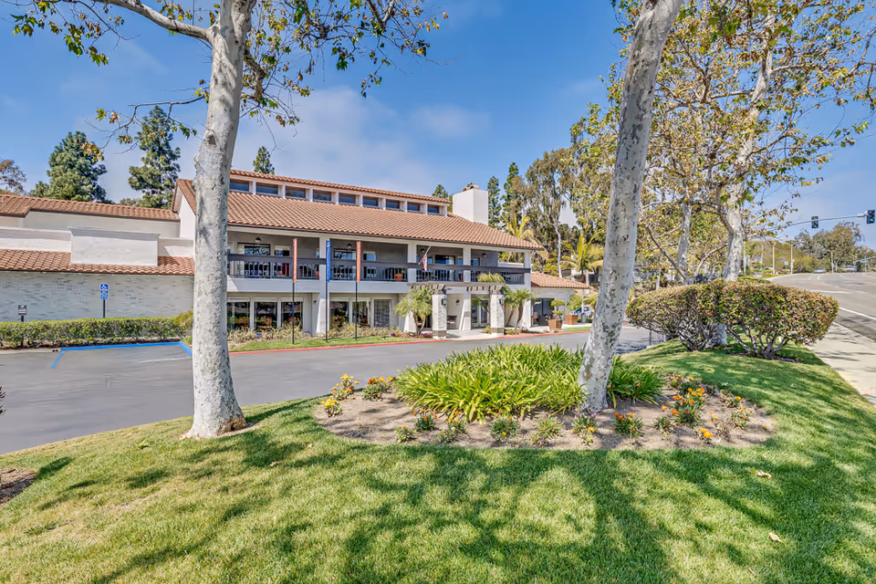 Two-story Encinitas Senior Living building with landscaping and a parking lot.