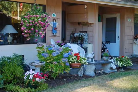 Front entrance of Warm Beach Senior Community with colorful potted flowers.