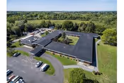 Aerial view of Auburn Rehabilitation and Nursing Center with parking lot and surrounding trees.