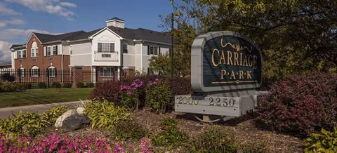 Waltonwood Carriage Park exterior with a landscaped entrance and sign.