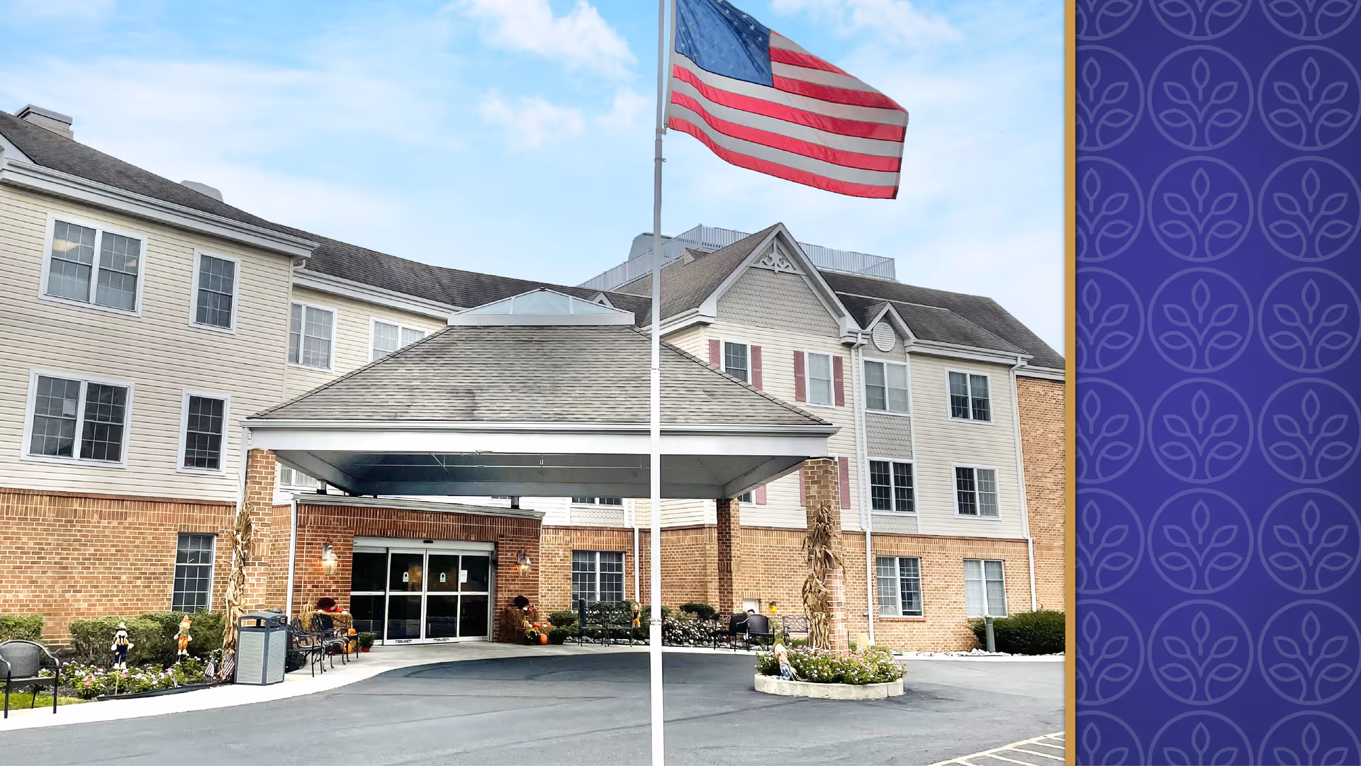 Front exterior view of Oxford Crossings facility with a covered entrance, American flag on a flagpole, and a three-story building with brick and siding exterior under a partly cloudy sky.