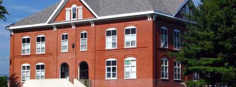 Larrabee Village senior living facility building with white-trimmed windows and trees.