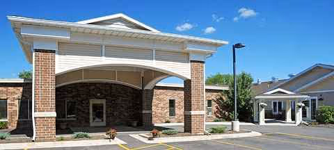 Front of Geneva Lake Manor senior living facility, brick entry and covered driveway.