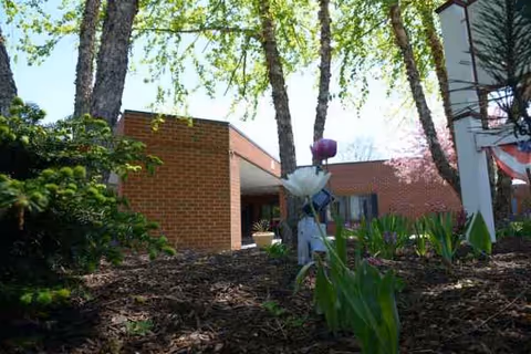 Exterior view of Absolut Care-Three Rivers with brick building, trees, and landscaped foreground.