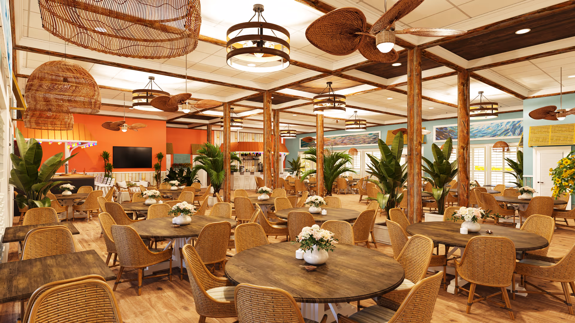 A spacious dining room with multiple round wooden tables surrounded by wicker chairs. Each table has a white vase with flowers. The room features wooden beams, ceiling fans with woven blades, and large green plants. The walls are painted in warm tones with some artwork and a large flat-screen TV mounted on one wall. The floor is wooden, and the lighting includes hanging woven lamps and circular ceiling lights.