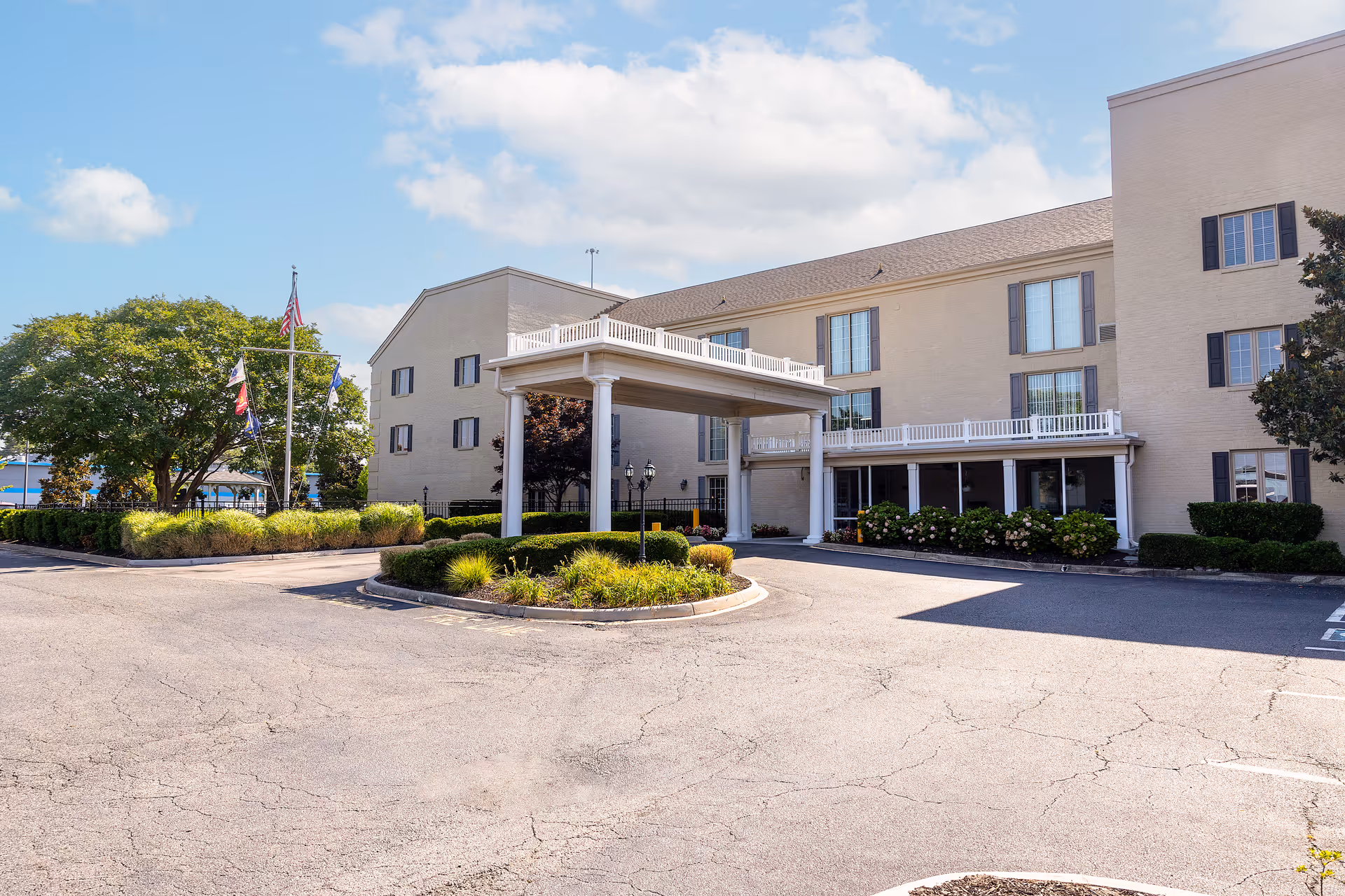 Exterior view of Commonwealth Senior Living at Leigh Hall with porte-cochere entrance and landscaping
