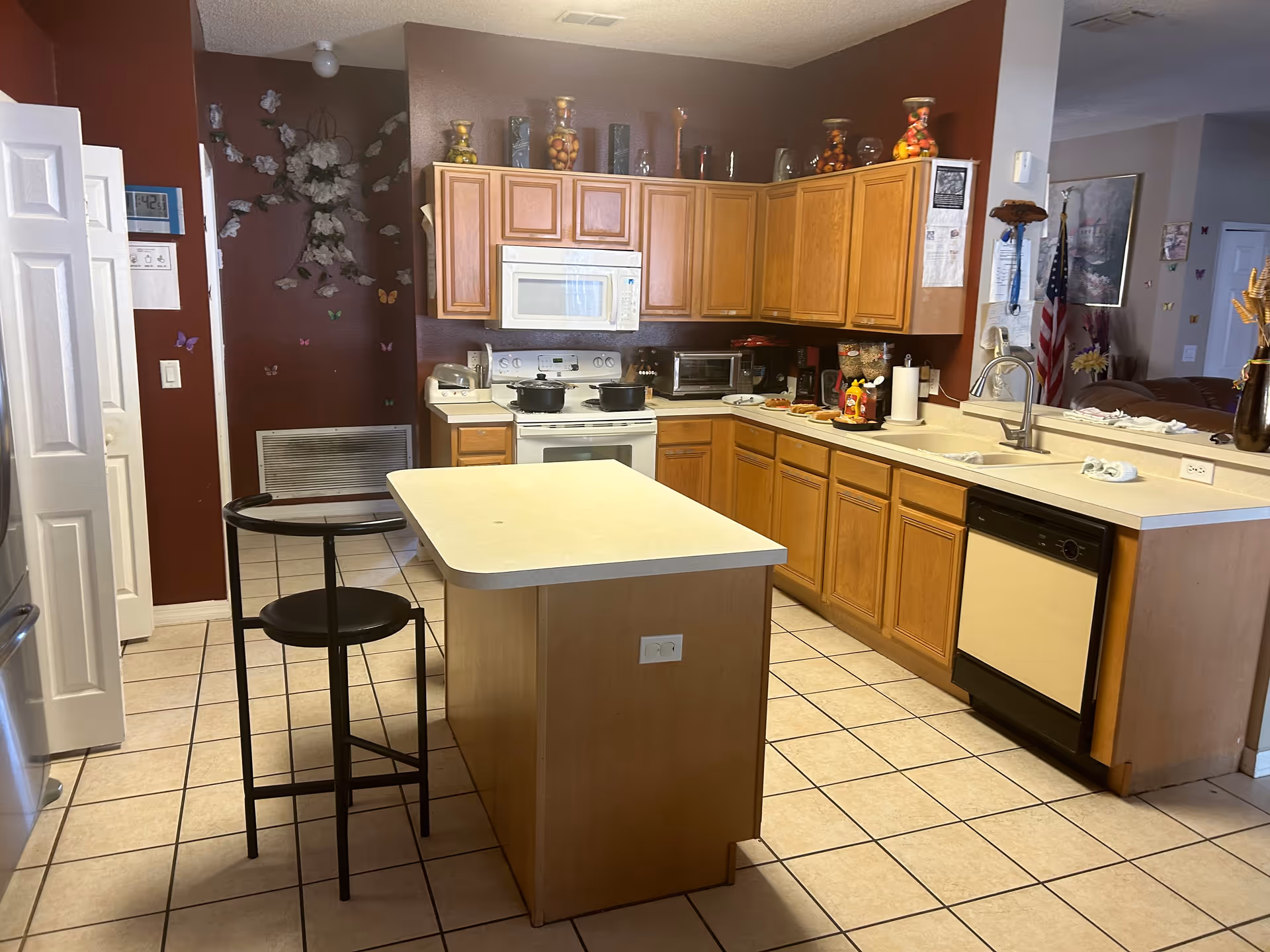 A spacious kitchen in a senior living facility with an island and wooden cabinets.