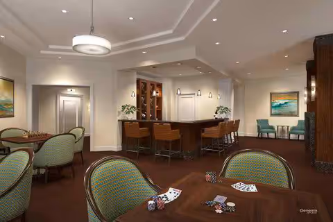 Spacious senior living common room with a central bar, game tables with cards and chips, and multiple seating areas.