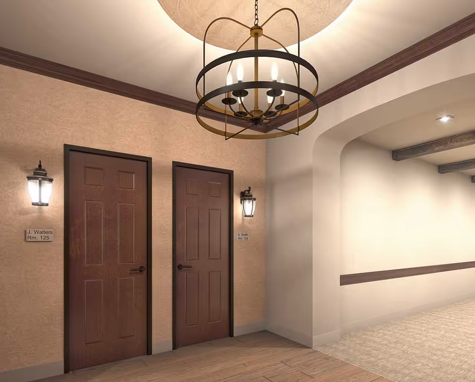 A well-lit interior hallway with two wooden doors labeled with room numbers, wall lanterns, an arched entryway, and a decorative ceiling chandelier.