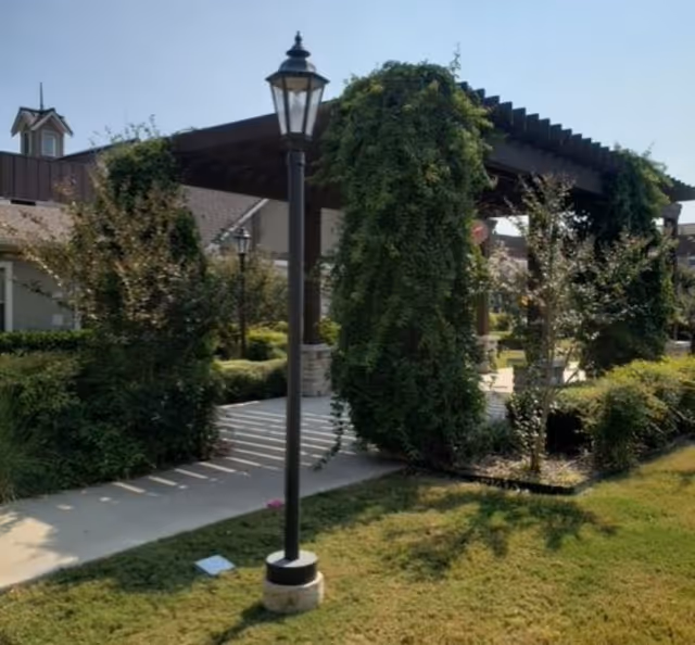 Exterior view of Village on the Park Stonebridge Ranch with a pergola and greenery.
