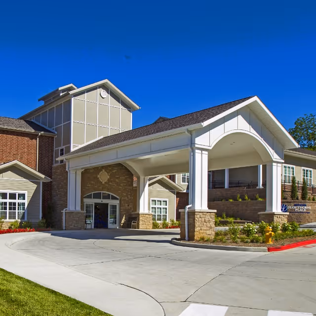 Front entrance of Bethesda Hawthorne Place with a covered porte-cochère and landscaped driveway.
