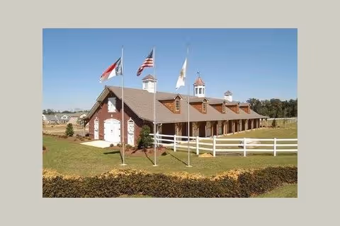 Front exterior of a red-brick residential care home with flags.