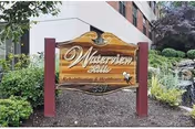 Wooden 'Waterview Hills' rehabilitation and healthcare sign mounted on posts in landscaped grounds in front of a multi-story building.