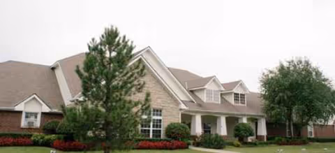 Exterior of Brookdale Edmond Danforth senior living facility with lawn, trees, and entry porch.
