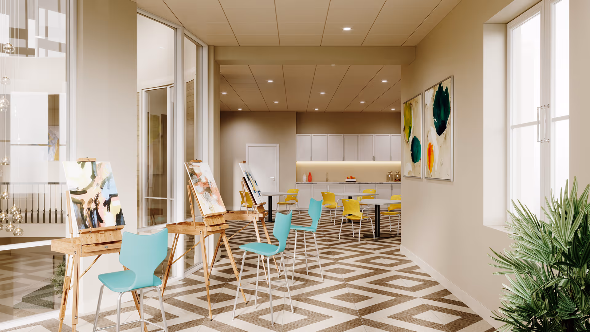 Bright multipurpose activity and dining room with easels and colorful chairs arranged on a patterned floor and a kitchenette in the back.