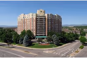 A large RiverPointe Senior Community building viewed from the street with trees surrounding