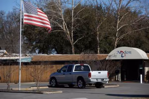 Exterior view showing Focused Care at Mount Pleasant entrance, flagpole, and a pickup truck.