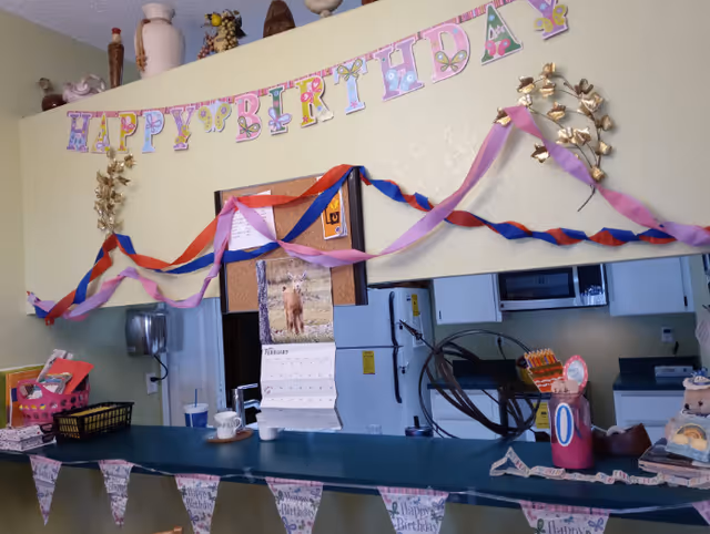 Ann's House-Oakwood kitchen area decorated with birthday banners and colorful streamers.