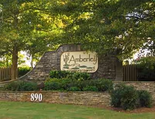 Stone entrance sign for Amberley Senior Community with surrounding landscaping.
