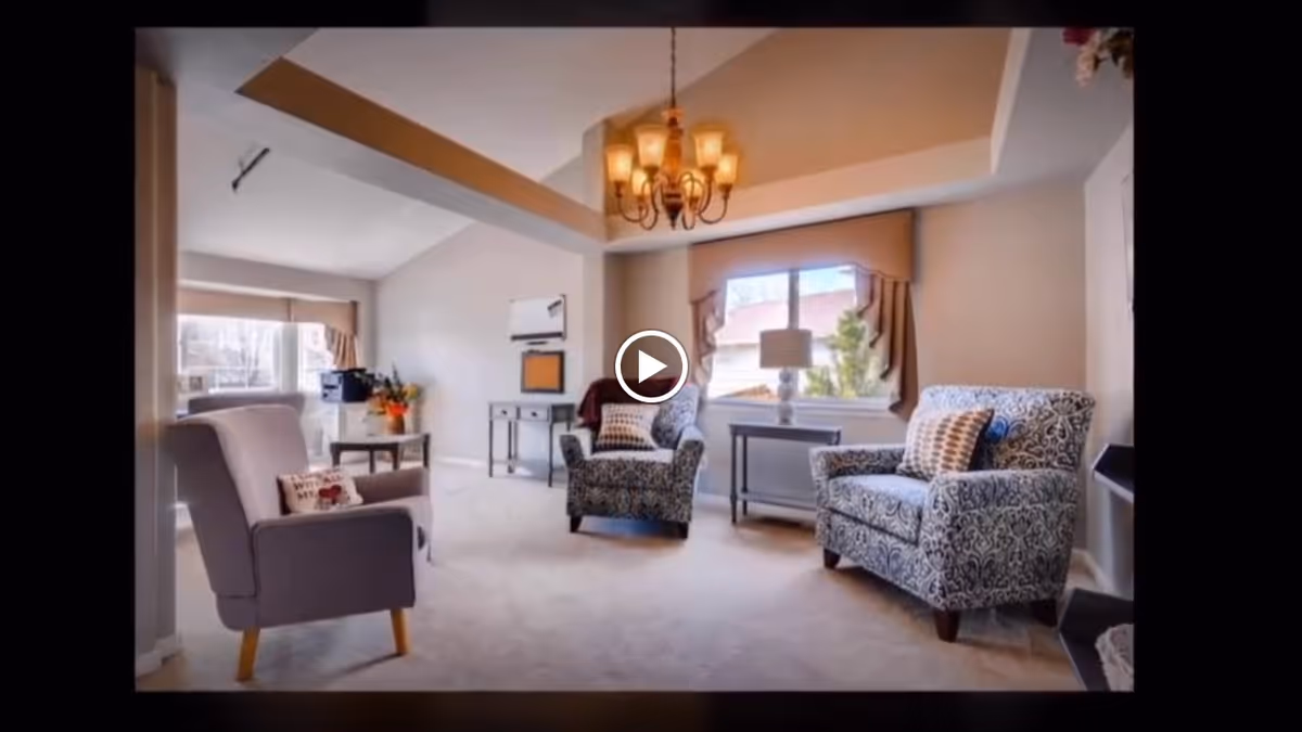 Bright living room with upholstered armchairs, side tables, a chandelier, and a window.