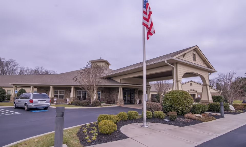 Exterior view of Morning Pointe of Lenoir City with flagpole and covered entrance.
