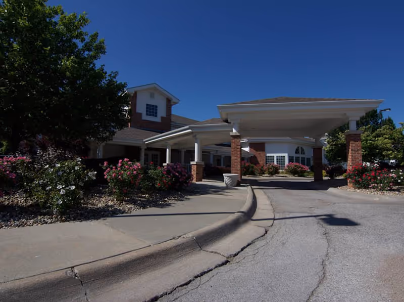 Front view of Fountain View Senior Living entrance with brick pillars and manicured landscaping.