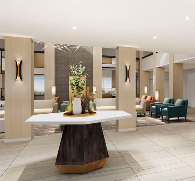 Modern, brightly lit senior living lobby with a central decorative table and multiple seating areas.
