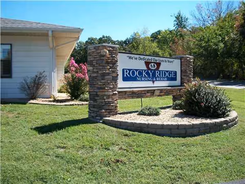 Stone pillar sign for Rocky Ridge Nursing & Rehab at outdoor front entrance.
