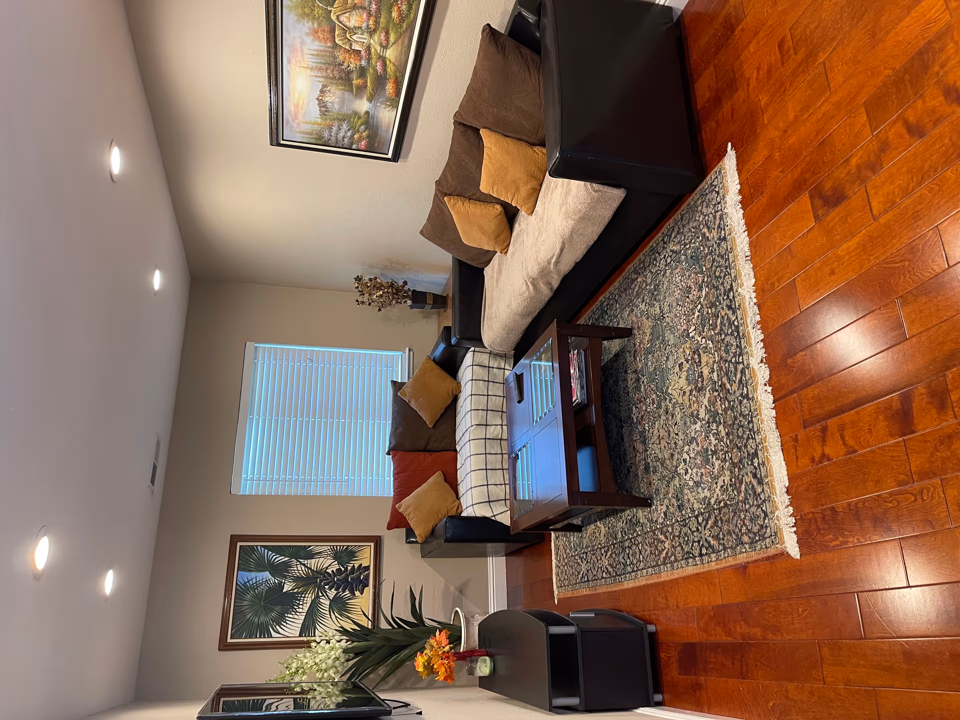 Cozy living room in a senior residence featuring sofas, rug, coffee table, and artwork.