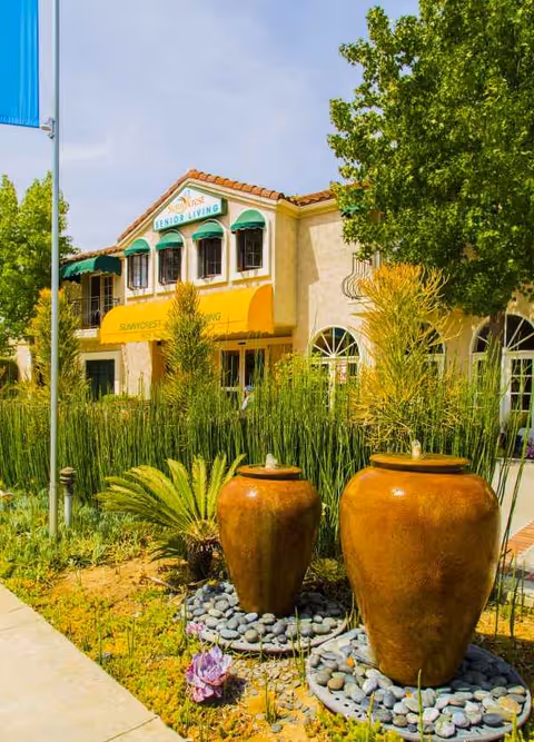 Sunnycrest Senior Living building exterior with green awnings and large planters.