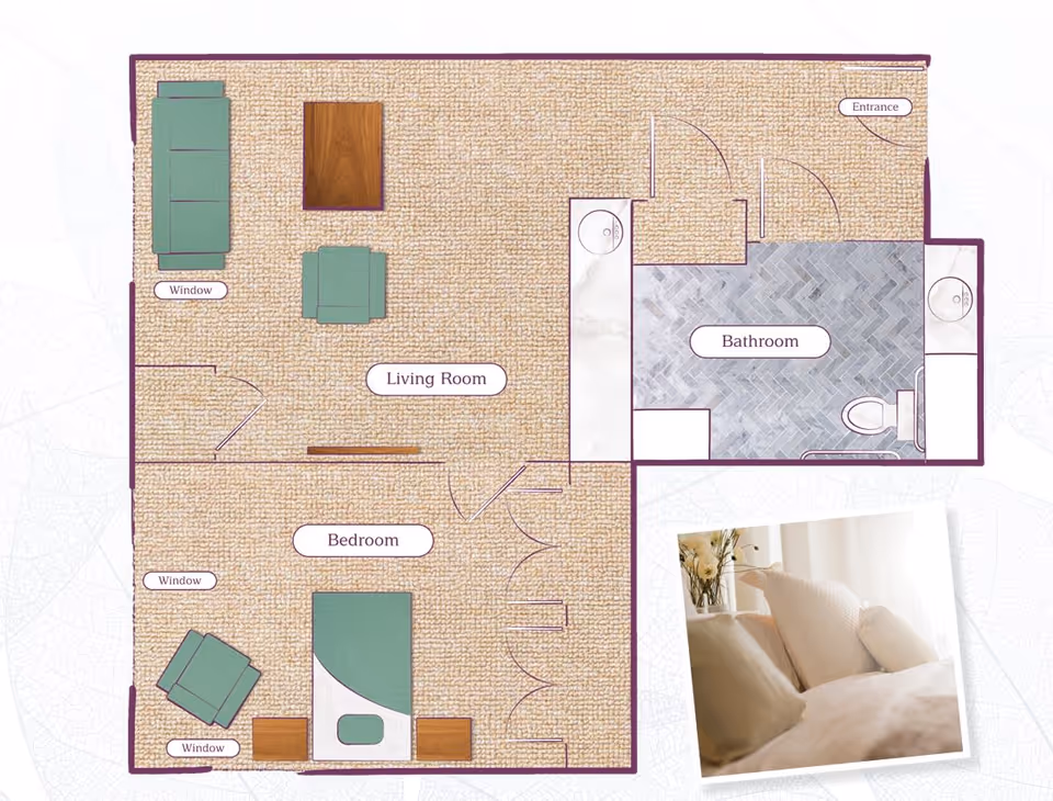 Floor plan of a senior living facility unit at The Pathways at Warrington showing a living room with sofa, chair, and coffee table, a bedroom with a bed and two nightstands, and a bathroom with a toilet and two sinks. There are windows in the living room and bedroom. An inset photo shows a close-up of pillows on a bed.