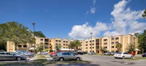 Front view of Brookdale Mandarin senior living campus with parking and palm trees.
