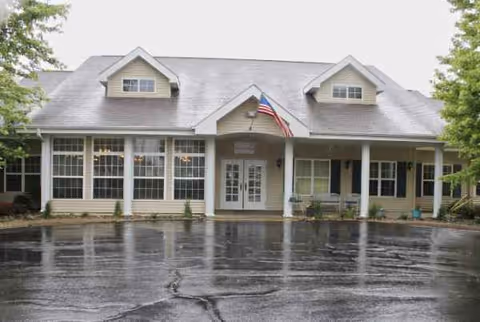 Front view of Floyd Senior Living building with pillars, windows, and an American flag.