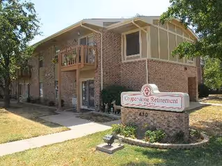 Front exterior of Copperstone senior living building with a sign
