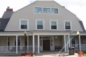 Front view of Peace Healthcare at Ridgeway Manor, a two-story beige building with a covered entrance.