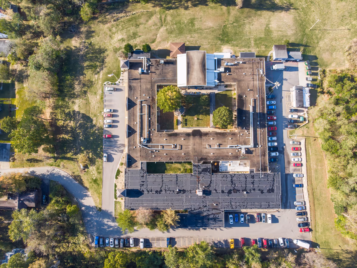 Aerial view of Eagle Pointe Healthcare Center showing the building with a central courtyard, surrounded by parking lots and green grassy areas with trees.