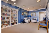 Comfortable sitting room with built-in bookshelves, armchairs, and blue-painted walls.