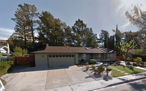 Front exterior of Evergreen Terrace senior living facility with driveway and landscaped yard.