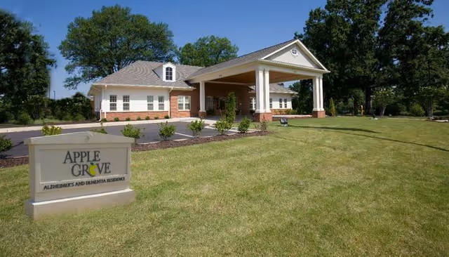 Exterior view of Apple Grove Alzheimer's and Dementia Residence with a lawn and sign