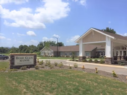 Exterior view of Rose Glen Manor with sign, front entrance, and landscaping
