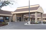Exterior entrance of Monument Health Taylorsville senior living center with stone columns and porte-cochere.