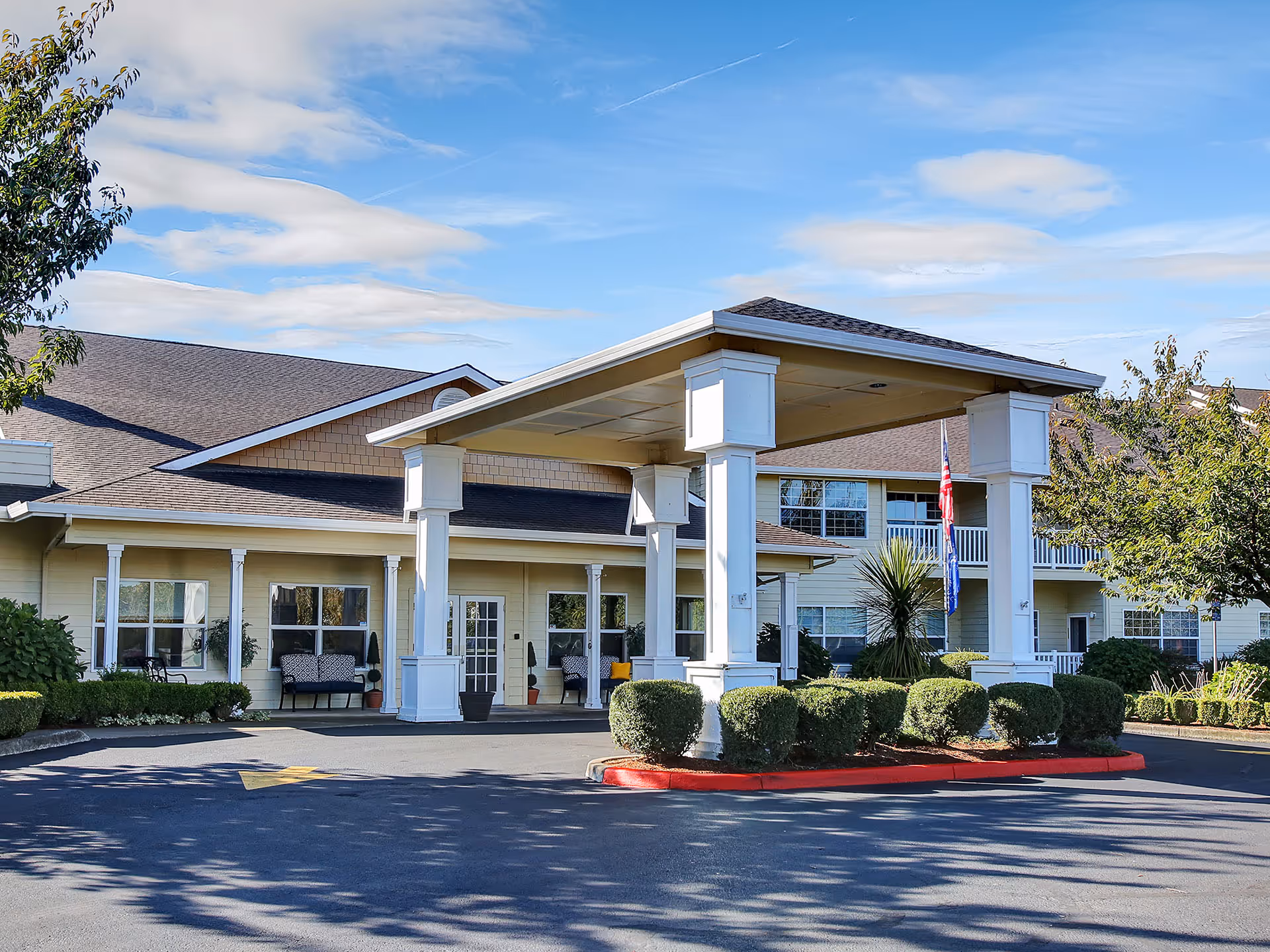 Front view of Prestige Senior Living Five Rivers facility with a covered entrance and landscaping