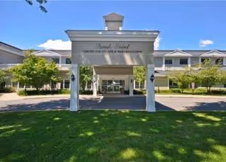 Exterior front view of Sands Point Center for Nursing and Rehabilitation entrance with white pillars.