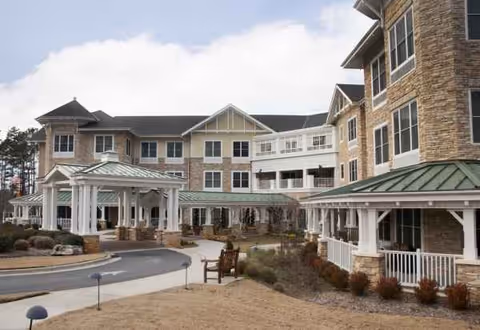 Sunrise of Cary senior living facility exterior with covered entrances and landscaped courtyard.