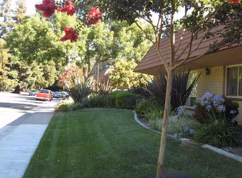 Exterior view of The WaterLeaf at Land Park with manicured lawn and walkway.